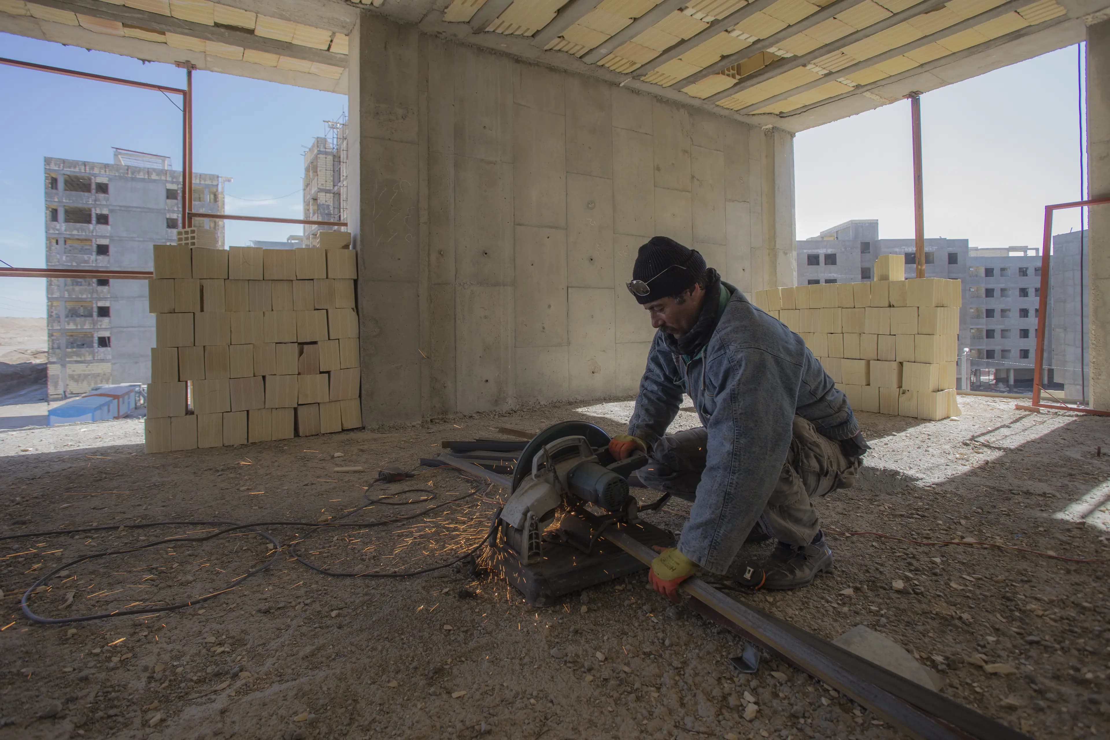 Ouvrier découpant un matériau sur un chantier de gros œuvre